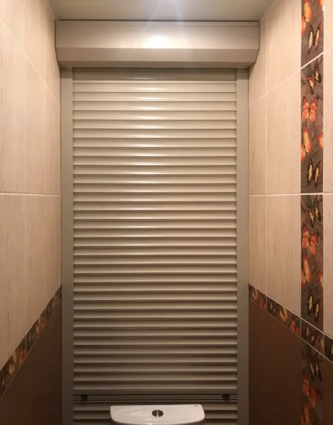 Узкий туалет с жалюзи на задней стенке