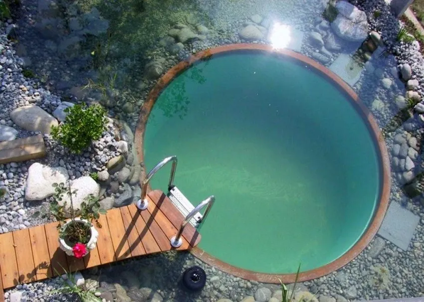 Круглый бассейн с небольшим деревянным мостиком